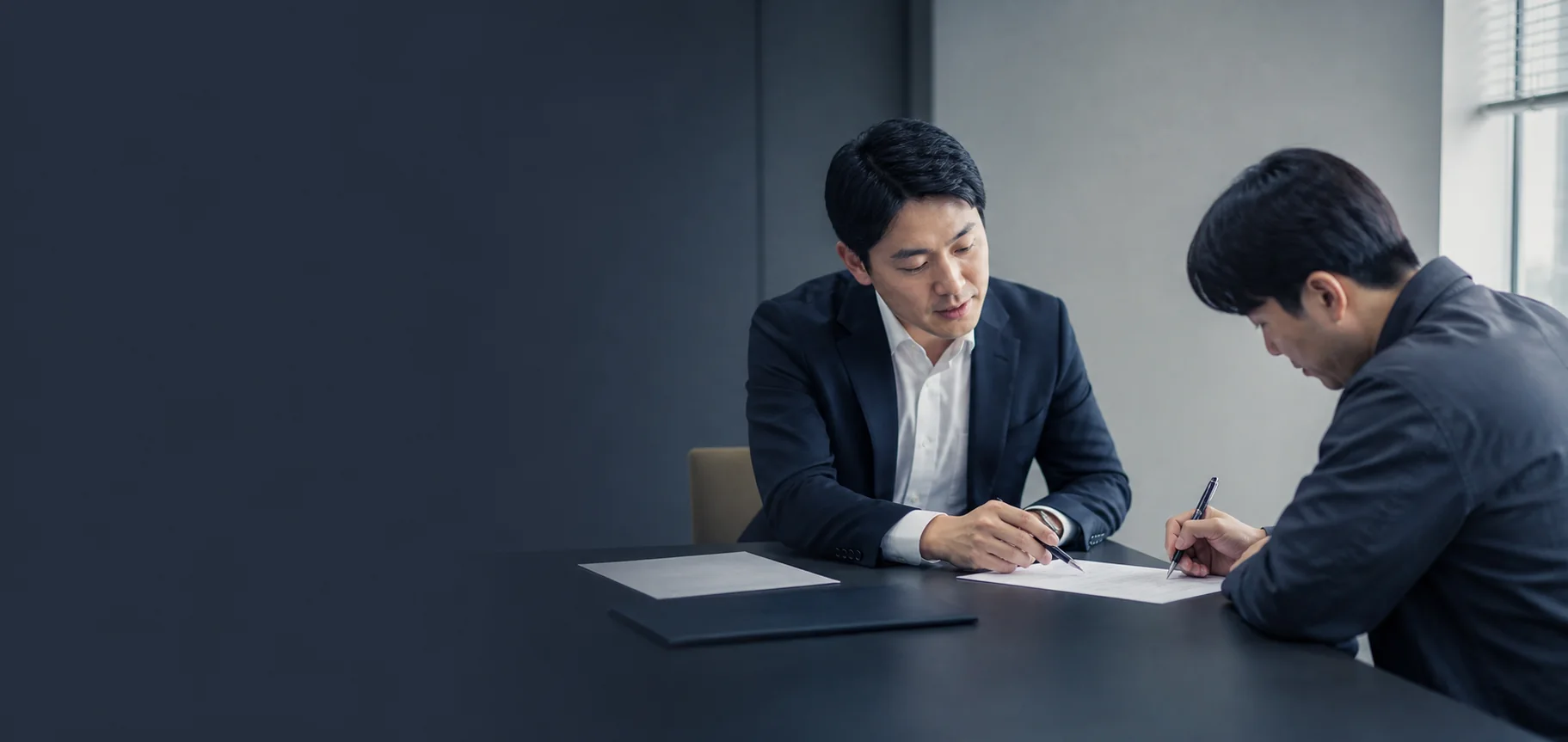 상담 테이블에서 계약서를 함께 확인하고 서명하는 모습
